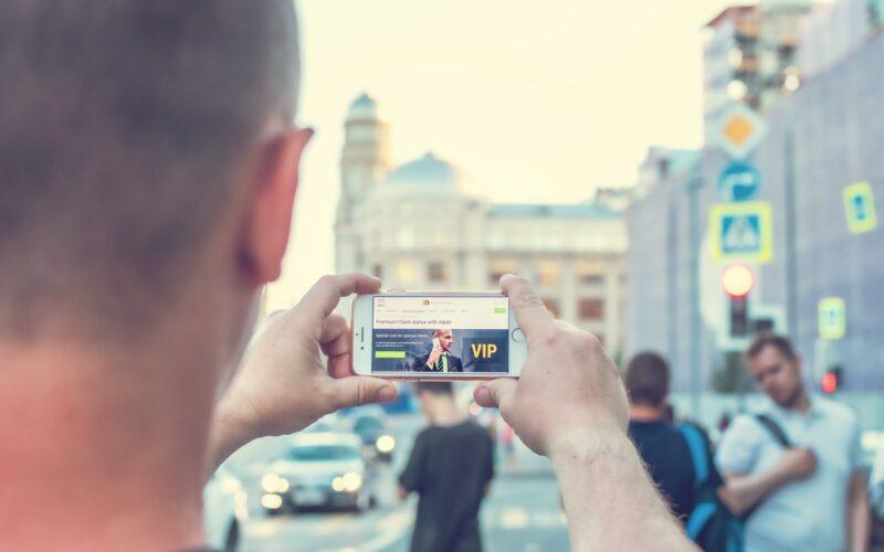 man standing near outdoor while holding white smartphone