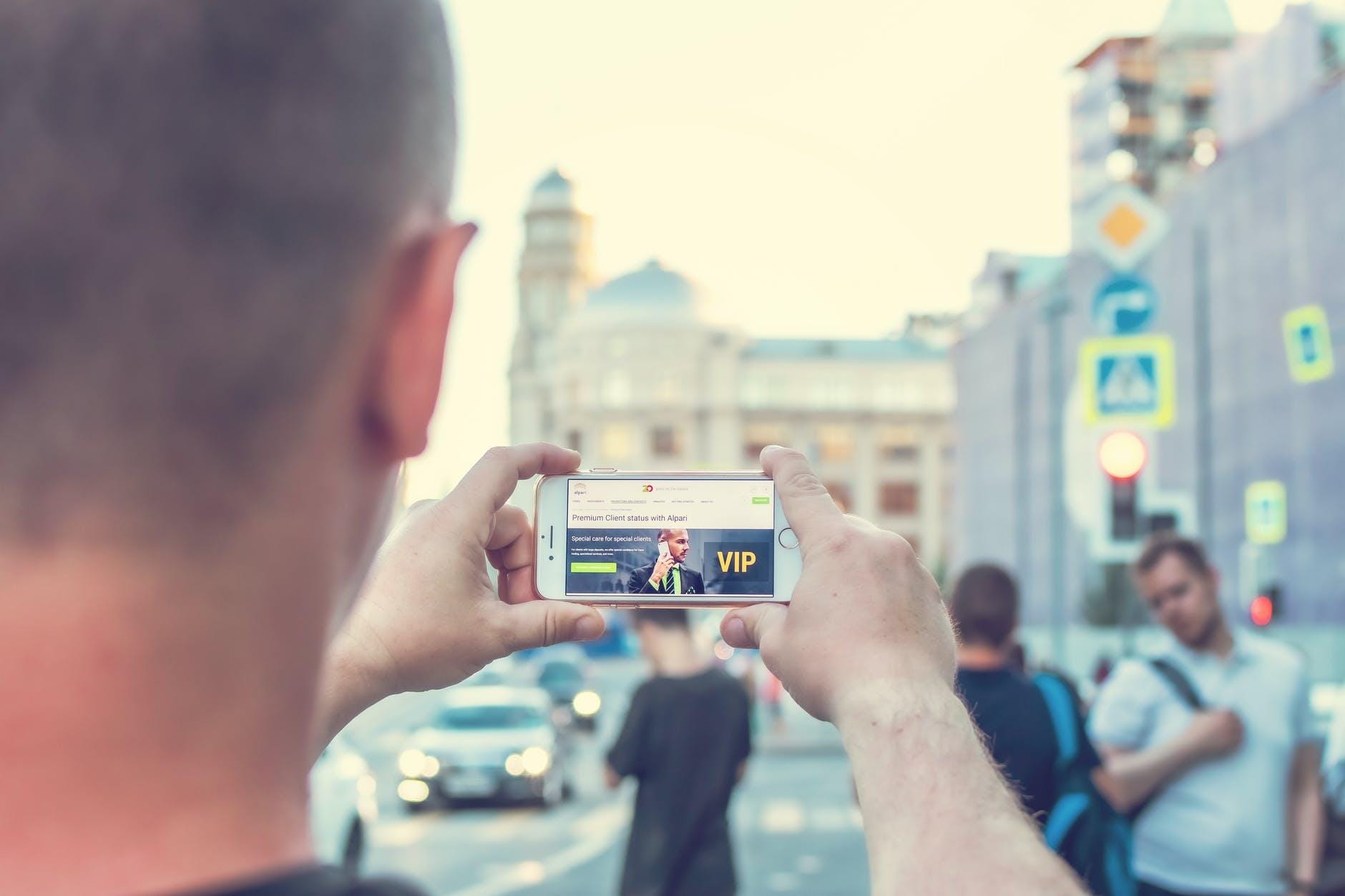 man standing near outdoor while holding white smartphone