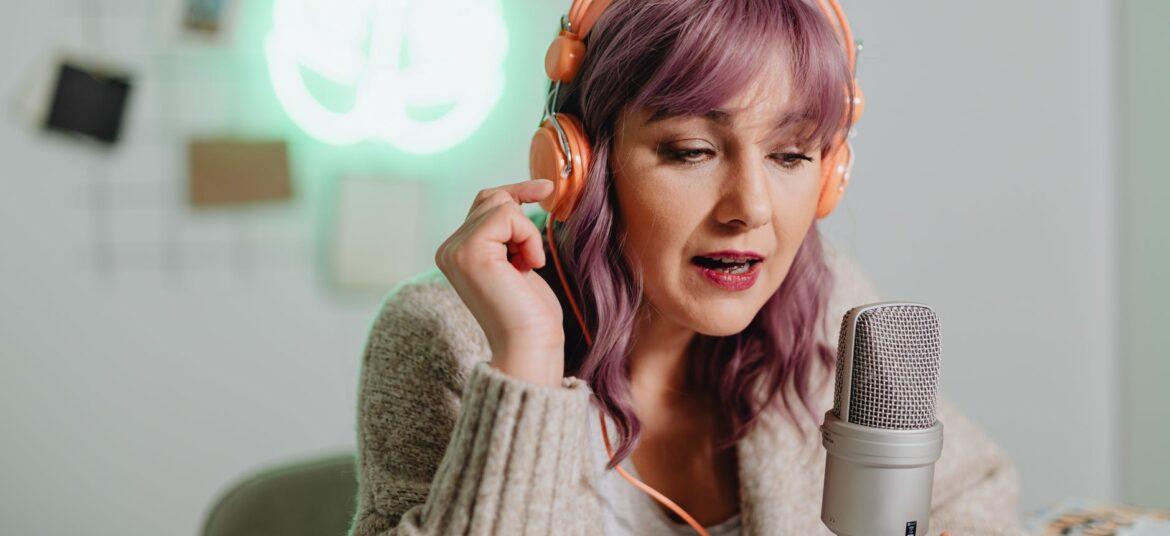 a woman talking on a microphone while wearing a headphone