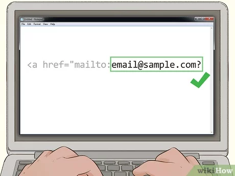 Cómo crear un enlace mailto con HTML  --Una persona escribiendo en una computadora portátil creando una dirección de correo electrónico.
